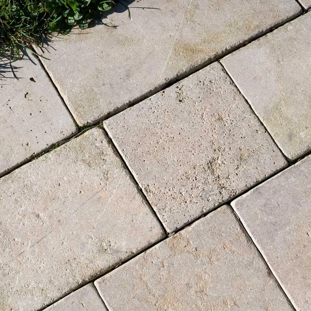 Warm beige tumbled limestone pavers with softened edges and a naturally aged surface