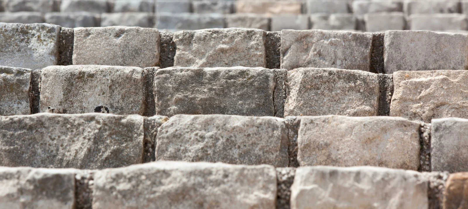 Rows of weathered natural stone showing softened, rustic tumbled edges